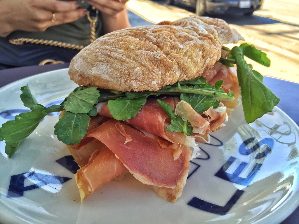 Famous Damus - sanduíche de pão ciabatta com ovos mexidos, presunto surryano e rúcula